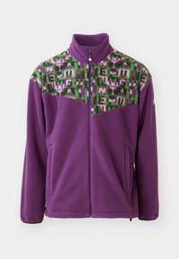 Fleecejakke i lilla, med en grønn og rosa geometrisk mønstered yoke. Inkluderer høy krage og glidelås foran med to sidelommer.