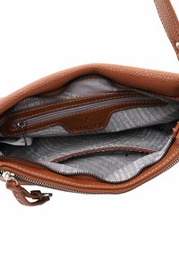 Sac à main en cuir marron avec un extérieur texturé, compartiment zippé et doublure imprimée grise. Dispose d'une poche interne pour l'organisation.