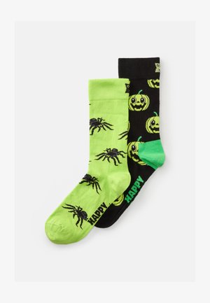Grüne und schwarze Socken mit Spinnen auf dem grünen Stoff und lächelnden Kürbissen auf dem schwarzen mit dem Text "HAPPY" in grün. Baumwollmischung.