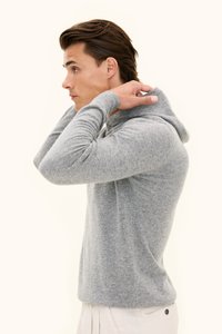 Lysegrå hættetrøje lavet af blødt materiale, med høj hals, tætsiddende pasform, lange ærmer og et minimalistisk design.