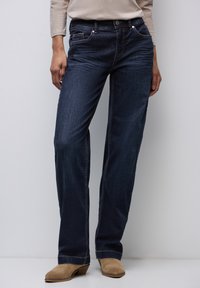 Mörkblå denimjeans med raka ben, utrustade med framfickor, diskreta sömmar och dragkedja med knappstängning.