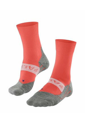 Chaussettes corail et grises avec une partie supérieure côtelée, semelle rembourrée et bande rayée arborant un logo. Le matériau semble synthétique et respirant.