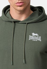 Olivovo zelená mikina s klokaním vreckom, nastaviteľnou šnúrkou a vyšívaným logom "Lonsdale London" s motívom leva.