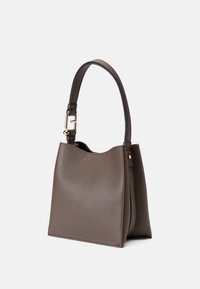 Bolso de mano de cuero marrón con un acabado texturizado. Presenta un asa sencilla y accesorios en dorado. Apertura distintiva en forma de mordida en la parte superior.