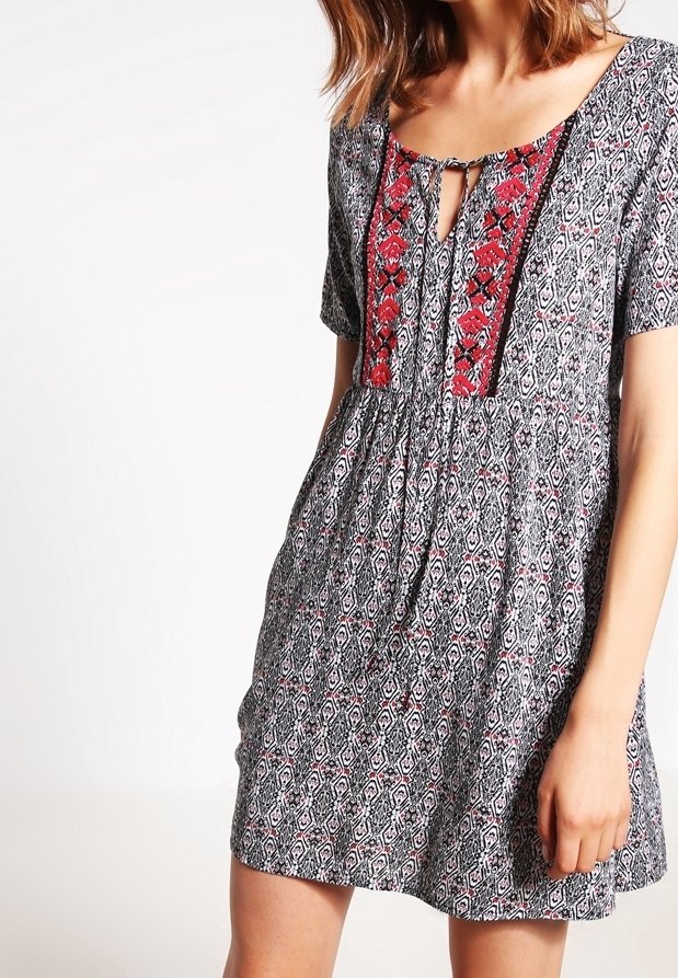Floral-patterned dress in black and white with a red embroidered neckline and short sleeves, featuring a keyhole opening at the front.