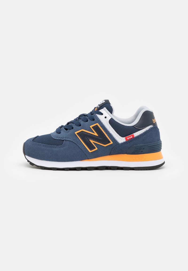 Blue and orange New Balance 574 sneaker with black and white sole, mesh and suede upper, and padded white collar on plain background.