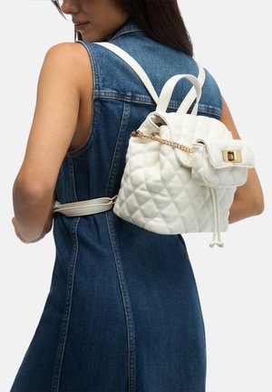 Weißer gesteppten Rucksack mit Kordelzugverschluss und einer kleinen Klapptasche. Ausgestattet mit goldenen Beschlägen und zwei Schultergurten.