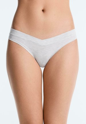 Woman's lower torso wearing light gray, V-shaped waistband briefs against a plain white background.
