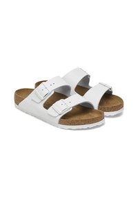 Sandales en cuir blanc avec deux sangles réglables, semelle en liège et semelle extérieure en caoutchouc. Présente un dessus texturé et une doublure intérieure lisse.