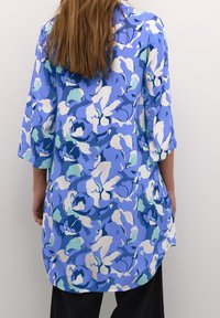 Florale Tunika in Blau- und Weißtönen, mit lockerer Passform, dreiviertel Ärmeln und abgerundetem Saum, versehen mit einer weichen Textur.