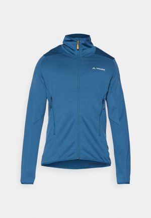 Blaue Zip-Jacke mit hohem Kragen, langen Ärmeln, zwei Seitentaschen, strukturiertem Stoff und kontrastierenden Schulterpaneelen. Logo auf der Vorderseite.