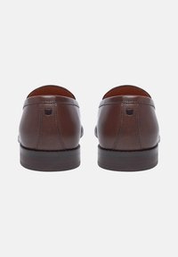 Braune Lederloafer mit glatter Oberfläche, abgerundetem Hinterteil und gestuften Holzabsätzen, ausgestattet mit zarten Nähten und einem kleinen Logodetail.