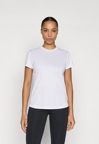 Weißes T-Shirt mit kurzen Ärmeln, rundem Halsausschnitt und glatter Textur, kombiniert mit schwarzen Leggings. Einfaches, klares Design ohne Muster.
