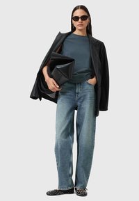 Sort læderblazer over en teal t-shirt, blå denim bredbenede jeans, sorte nitterede flats og en sort foldet clutch. Solbriller og øreringe.