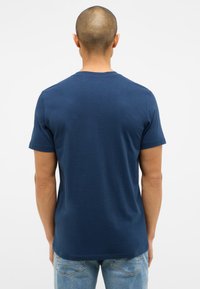 Granatowa bawełniana koszulka z krótkim rękawem i klasycznym okrągłym dekoltem, o gładkiej fakturze i minimalnym zdobieniu.