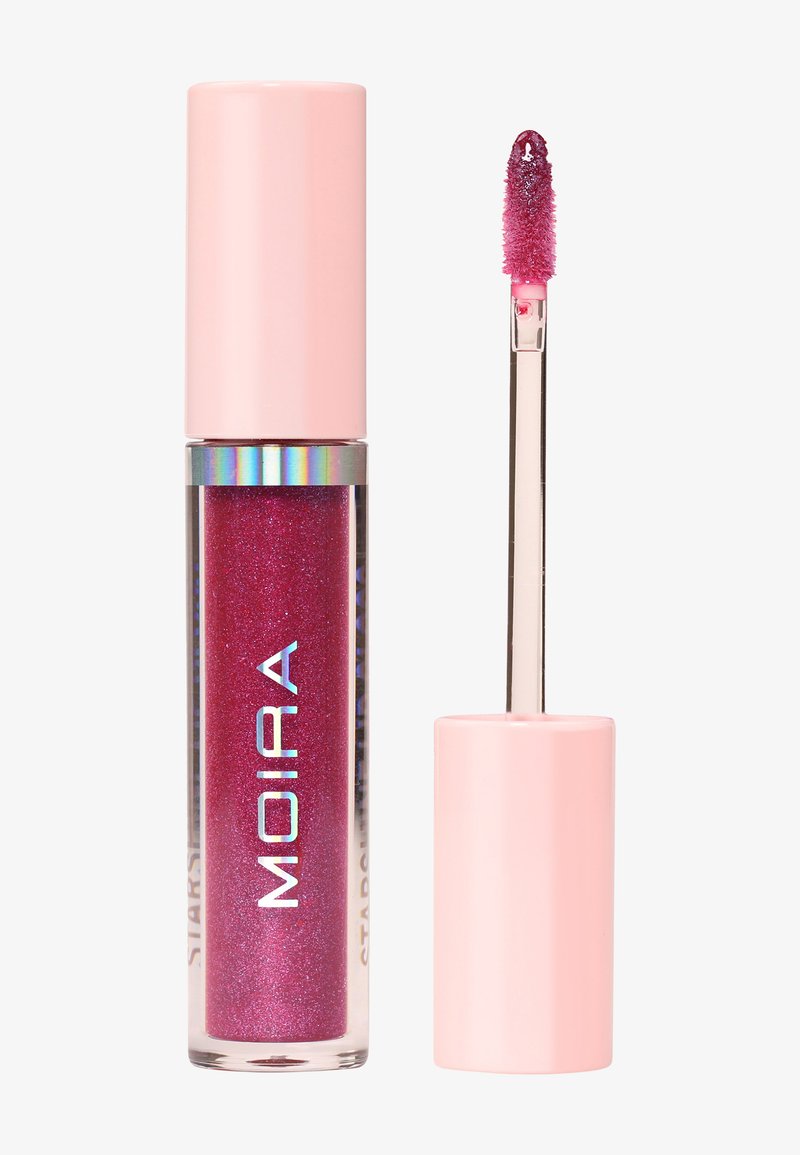Gloss à lèvres rose brillant avec paillettes dans un tube transparent étiqueté "MOIRA" à côté d'un applicateur avec un capuchon rose et un produit pailleté au bout.
