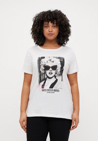 Hvit bomull T-skjorte med svart-hvitt trykk av en kvinne i solbriller, med rosa tekst som sier "Marilyn" og "De forente stater."