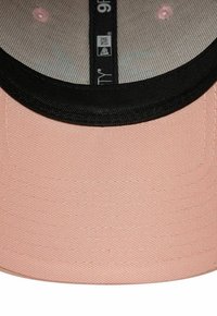 Kappe aus hellrosa Stoff mit schwarzer Krempe und innerem Rand. Verfügt über eine feine gerippte Textur und weiße Nähdetails. Kleine Markenlabel sichtbar.