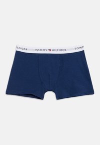 Ανδρικά μπλε μποξεράκια σε σκούρο μπλε χρώμα με λευκή μέση που φέρει το κείμενο "Tommy Hilfiger" και λογότυπο σε κόκκινο, λευκό και μπλε.