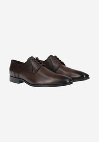 Bruine leren dresschoenen met een slank ontwerp, puntige neus en dunne veters. Kenmerken zijn een gladde textuur en subtiele stikdetails.