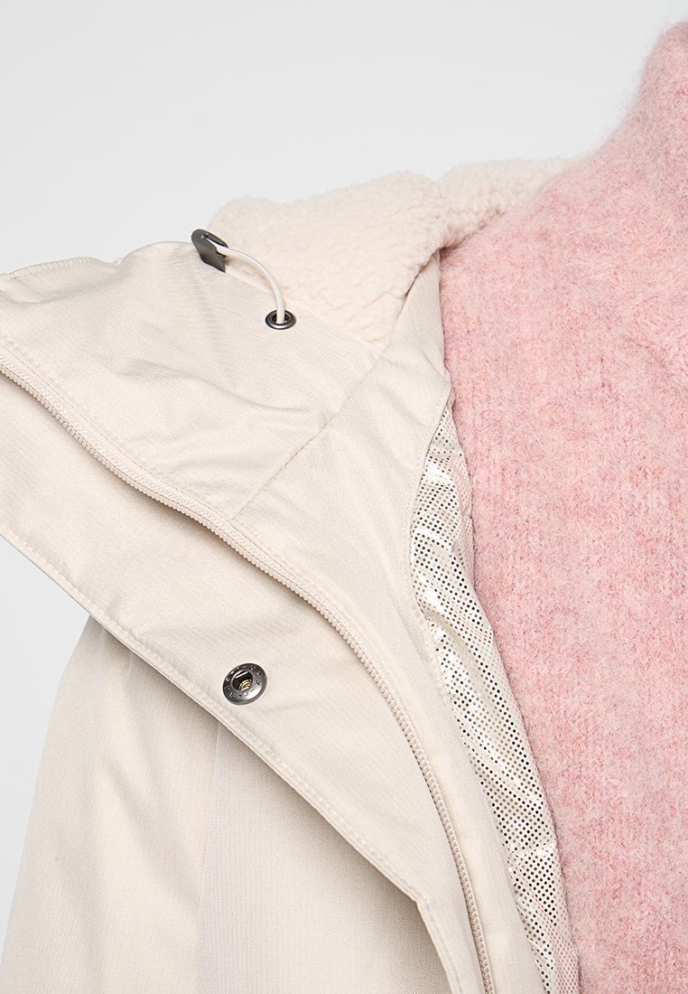 Hellbeige Mantel mit Fleece-Futter, ausgestattet mit einer Reißverschlusstasche und einer verstellbaren Kordelzugkapuze, akzentuiert durch eine weichrosefarbene Innenschicht.
