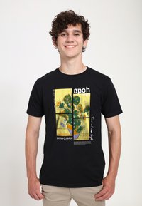 Camiseta de algodón negra con un diseño gráfico de girasoles amarillos, elementos de texto y un corte moderno. Textura suave y mangas cortas.