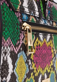 Torebka z wielokolorowego węża, z zielonymi, różowymi, niebieskimi i żółtymi geometrycznymi wzorami, złotym zamkiem błyskawicznym i czarnymi akcentami.