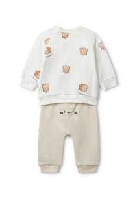 Conjunto de dos piezas para niños que incluye una sudadera blanca con estampados de un lindo personaje de pan y pantalones beige con un detalle de cara juguetona.
