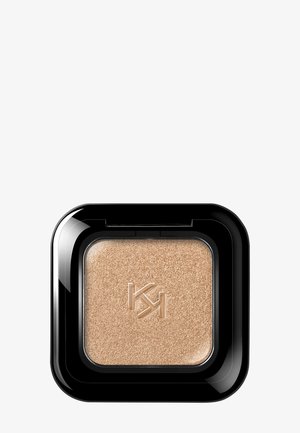 Étui noir compact avec fard à paupières poudre pressée beige embossé du logo stylisé "KH" sur une surface lisse.