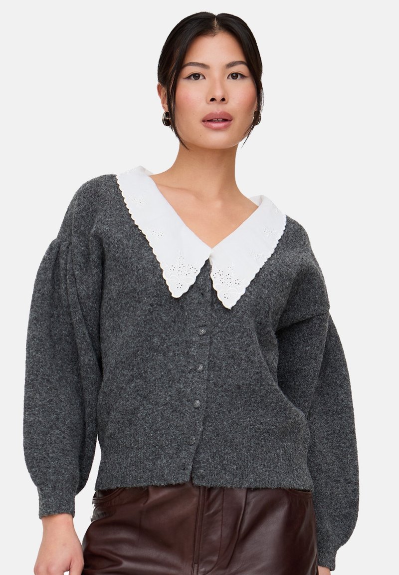 Grauer Strickcardigan mit weißem Spitzenkragen und Knopfverschluss. Mit aufgepufften Ärmeln und strukturierter Oberfläche.