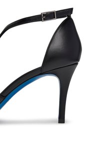 Scarpa nera con tacco alto, punta affusolata, materiale in pelle liscia, cinturino alla caviglia con fibbia argentata e dettaglio blu nella suola.