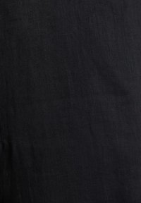 Tissu noir texturé avec un motif de tissage subtil et de légères rides, montrant une vue rapprochée de la surface du matériau.