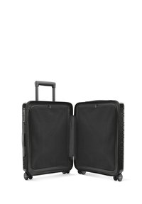 Valise rigide noire, avec une poignée télescopique et quatre roues. L'intérieur comprend des compartiments en maille, offrant un rangement organisé.