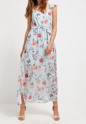 Maxi šaty z lehké modré květinové látky s volánkovými ramenními popruhy, páskem v pase a vysokým rozparkem na stehně s růžovými a červenými květy.
