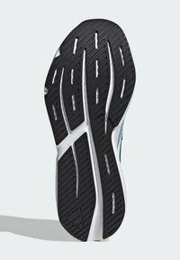 Schwarze Gummisohle mit einem strukturierten Profildesign, das weiße Akzente und eine geschwungene, konturierte Form aufweist.