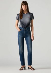 Raitapaita tummansinisestä ja valkoisesta, korkeavyötäröiset siniset farkut ja mustat korkokengät. Sujuva kangas, slim fit -malli ja klassinen farkkusuunnittelu.