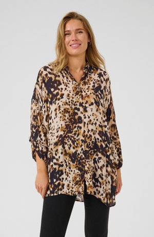Camicia con bottoni in stampa leopardata beige e marrone, con una vestibilità ampia e maniche arrotolate. Tessuto leggero con una superficie liscia.
