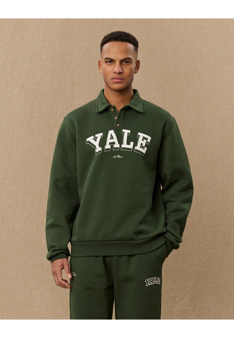 Dark green sweatshirt with a collared neckline, featuring "YALE" in white lettering across the chest and ribbed cuffs and hem.