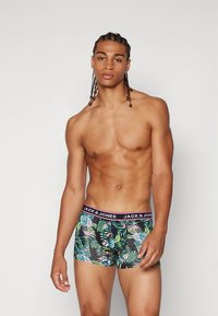 Bokserice s tropskim uzorkom lišća u zelenoj i ružičastoj boji, s crnim pojasom na kojem je logo "JACK & JONES". Mekani materijal, uski kroj.