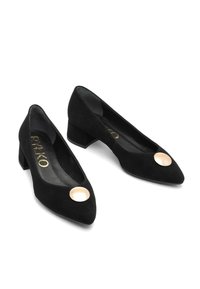 Černé semišové dámské boty na nízkém podpatku s špičatou špičkou a kulatými zlatými dekorativními knoflíky na vrchu, vystavené na bílém pozadí.