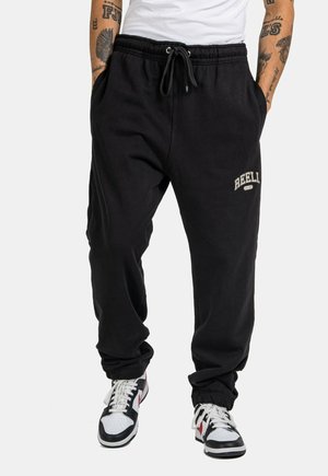 Schwarze Jogginghose aus weichem Baumwollmaterial. Sie verfügt über einen elastischen Bund mit Kordelzug, Seitentaschen und ein aufgesticktes Logo auf der Vorderseite.