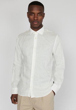 Camicia di lino bianca con maniche lunghe, colletto button-down e una texture sottile. Presenta un taglio dritto e polsini con dua bottoni.