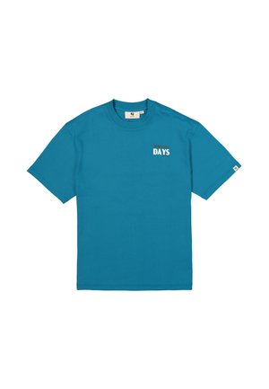 Turquoise katoenen T-shirt met korte mouwen, een ronde hals en "DAYS" in het wit gedrukt aan de linkerkant. Standaard pasvorm, gladde textuur.