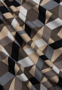 Patterned fabric with geometric shapes in shades of black, gray, beige, and white; soft texture with a slight sheen.