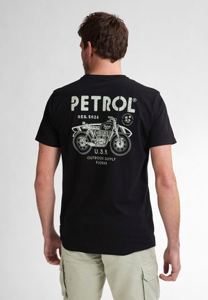 Schwarzes Baumwoll-T-Shirt mit einem Grafikdesign eines Motorrads und dem Text "PETROL" in heller Farbe, auf der Rückseite platziert.