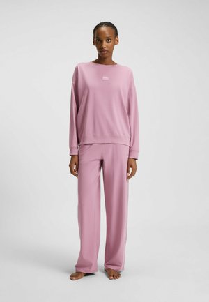 Helles pinkes Sweatshirt und lockere Hose aus weichem Material, mit einem minimalistischen Logo auf der Brust und einer lässigen Silhouette.