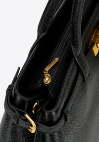 Zwarte leren handtas met een gestructureerd oppervlak, gouden hardware, ritssluiting en dubbele handvatten. Het interieur heeft organisatorische compartimenten.