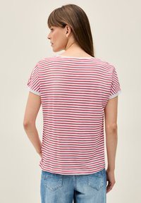 Camiseta de rayas rojas y blancas con mangas cortas, cuello redondo y un corte relajado, hecha de suave tela de algodón.
