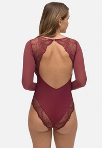Bodysuit en un profundo burdeos con mangas largas. Presenta un intrincado detalle de encaje en la espalda y el escote, además de un diseño de espalda baja.
