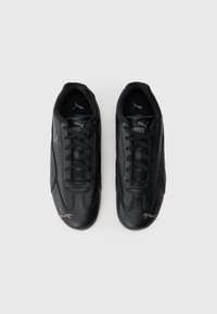 Pantofi sport negri din piele netedă, cu un design cu șireturi, vârf rotund și logo argintiu Puma pe lateral.